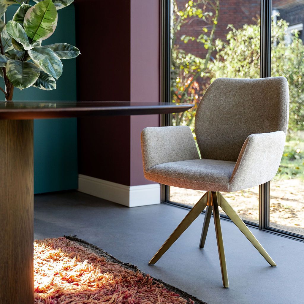 Draaistoel met gouden onderstel aan organische vorm eettafel