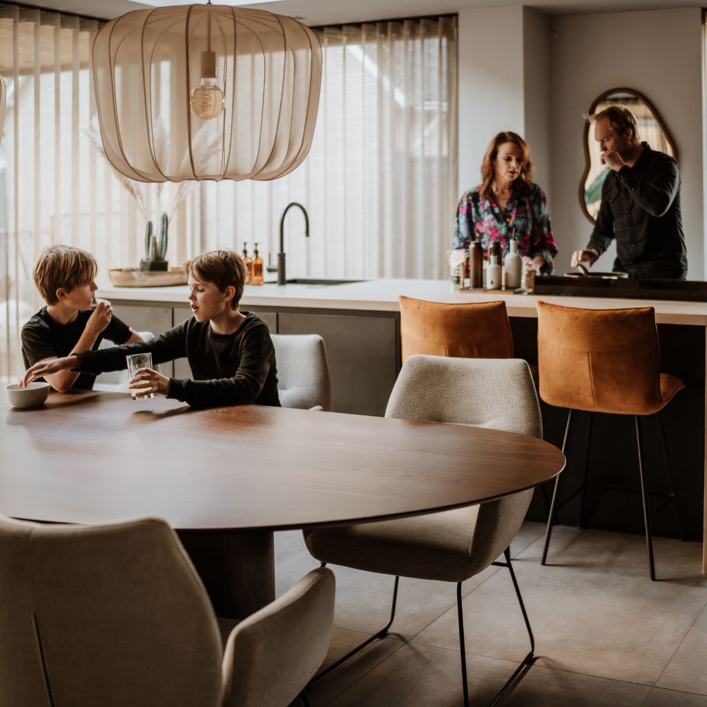 Familie aan tafel en in de keuken