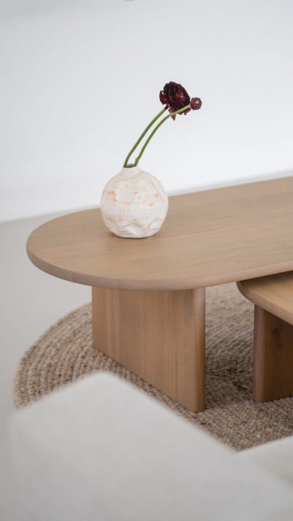 Plat ovale salontafel met vaas en bloem erop